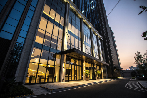 Modern commercial building entrance at dusk, representing Electrical Compliance, Energy Appraisals and commercial energy services